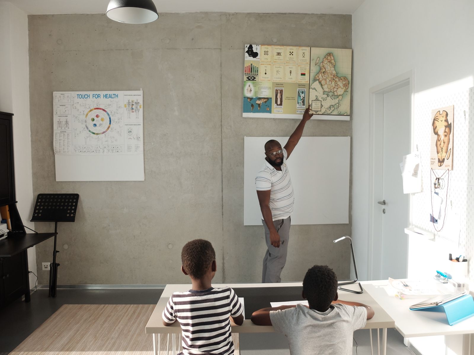 Illustrative teacher mentoring pupils in a classroom, not the actual school or pupils